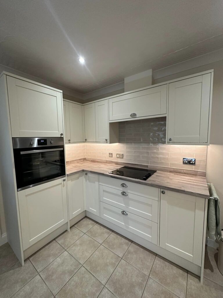 Modern kitchen units with white cupboard doors and grey wooden countertops